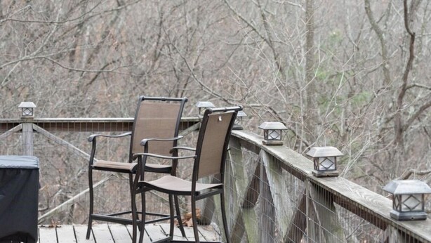 A wooden deck with two chairs and two lanterns. - Mountain Cottage with Private Views and Hot Tub!! (Shenandoah)