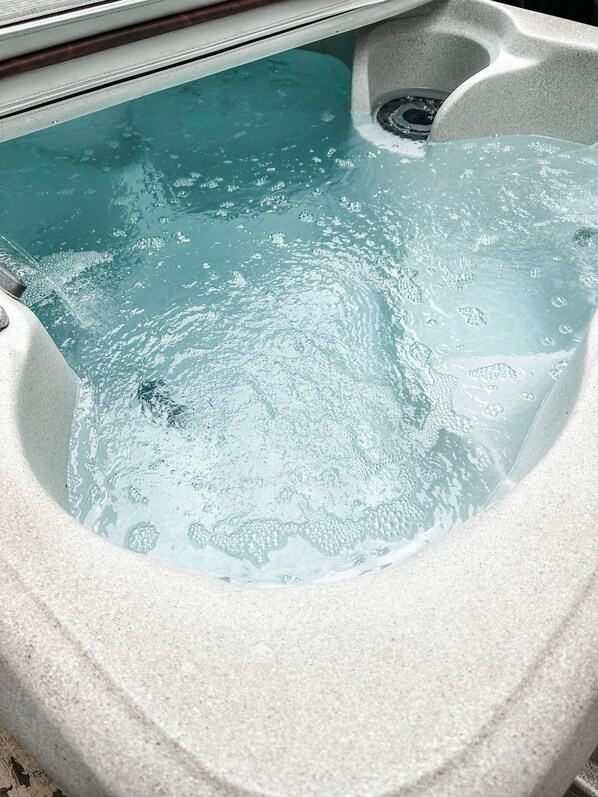 Ein Whirlpool mit klarem Wasser und sichtbaren Blasen, was darauf hindeutet, dass er genutzt wird.