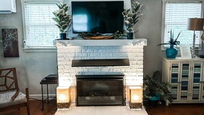 A living room with a fireplace, a television, and a patterned rug. - Mountain Cottage with Private Views and Hot Tub!! (Shenandoah)