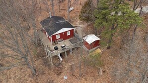 A red house with a metal deck and a small shed. - Mountain Cottage with Private Views and Hot Tub!! (Shenandoah)