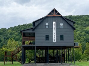 Un bâtiment à deux étages, à l’extérieur sombre, sur lequel est accrochée une grande banderole avec l’inscription « DERNIER de mon ESPÈCE ».