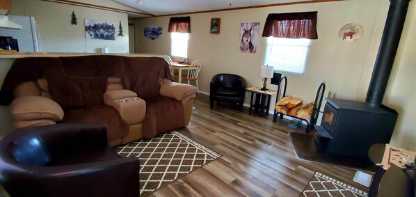Una sala de estar acogedora con sofá, chimenea y comedor con mesa y sillas.