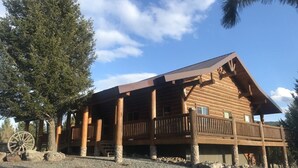 A wooden log cabin with a balcony and a large wheel. - Log Home on the Blackfoot River (Lincoln)