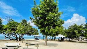 Ein Strand mit Holzbanken und einem Pavillon.