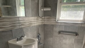A bathroom with a toilet, sink, and bathtub. - Cozy 3 bedroom house , pet friendly , yard (Portsmouth)