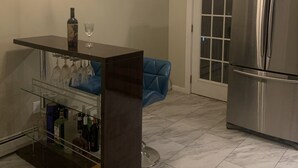 A kitchen with a bar area, a refrigerator, and a ceiling fan. - Cozy 3 bedroom house , pet friendly , yard (Portsmouth)
