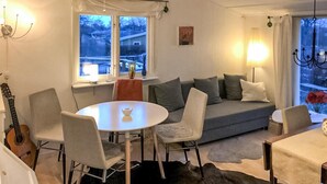 A cozy living room with a round dining table, grey sofa, and a guitar. - 2 bedroom cozy home in Ramdala (Ramdala)