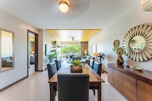 Un espace repas moderne avec une longue table, des chaises et un ventilateur de plafond.