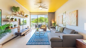 A modern living room with a sofa, coffee table, and decorative items on shelves.