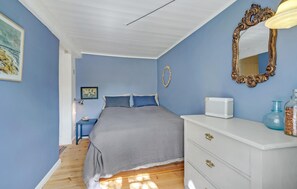 A bedroom with a bed, dresser, mirror, and artwork on the wall. - 3 bedroom cozy home in Fanø (Fanø)