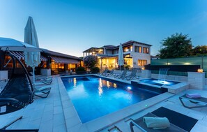 A swimming pool with lounge chairs, a hot tub, and a restaurant with outdoor seating. - Luxurious home in Vir with sauna (Vir)