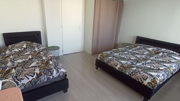A room with two beds, a wardrobe, a small table, and a curtain. - APPRENTICE AMBILLY (Ambilly)