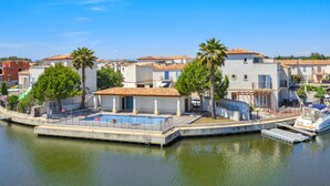 Une propriété située au bord de l’eau, dotée d’une piscine, d’un quai pour bateaux et d’un petit bateau.