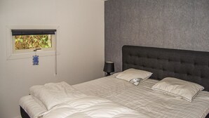 A bedroom with a bed, a window, a nightstand, and a lamp. - 2 bedroom nice home in Figeholm (Figeholm)