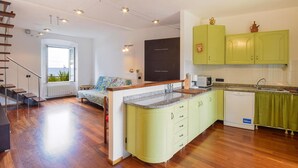 Una cocina moderna con armarios verdes, una isla integrada y vistas al mar.