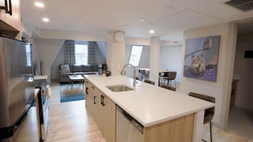 A modern kitchen with a central island, built-in appliances, and a dining area with a view.