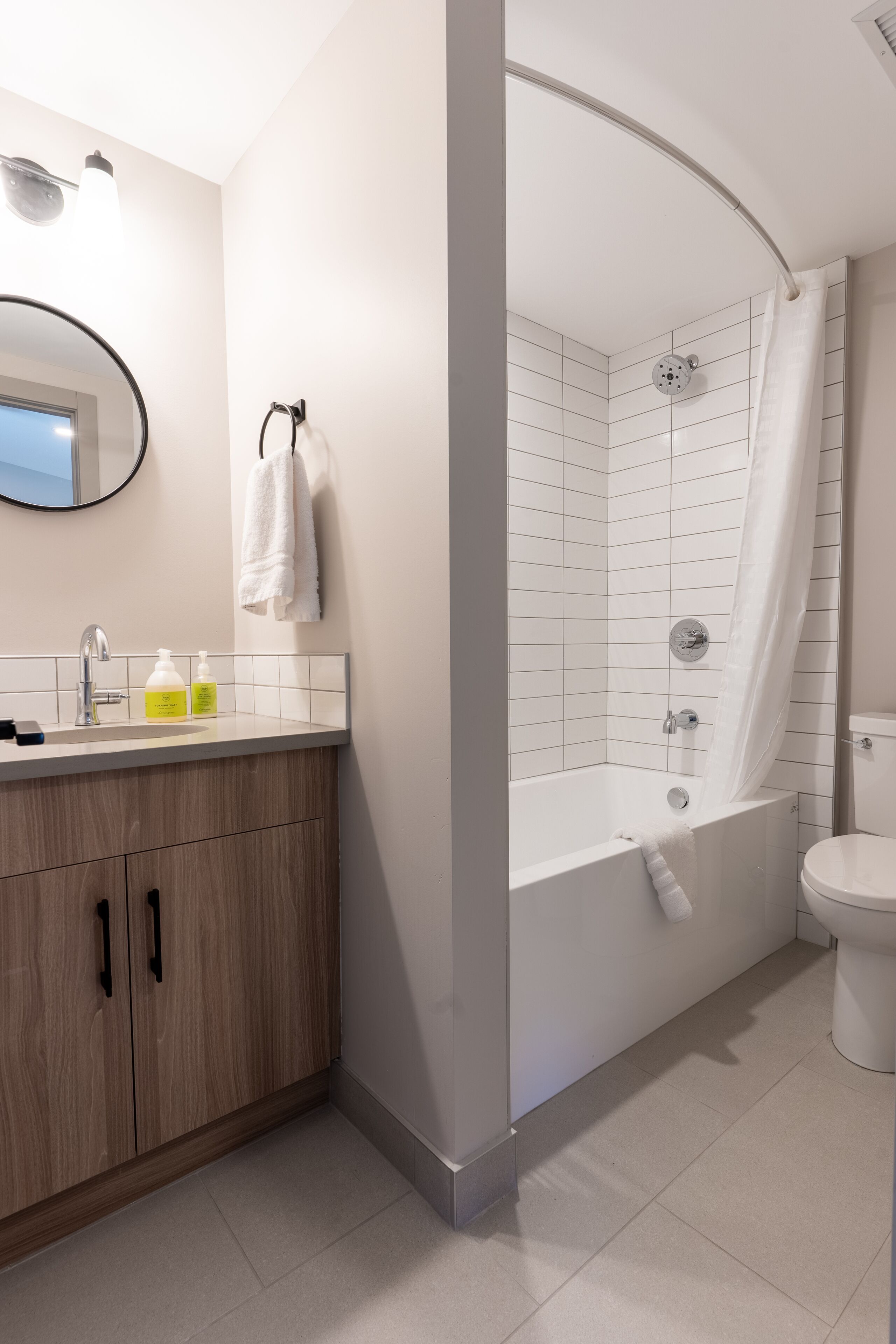 A modern bathroom with a shower, toilet, and vanity.