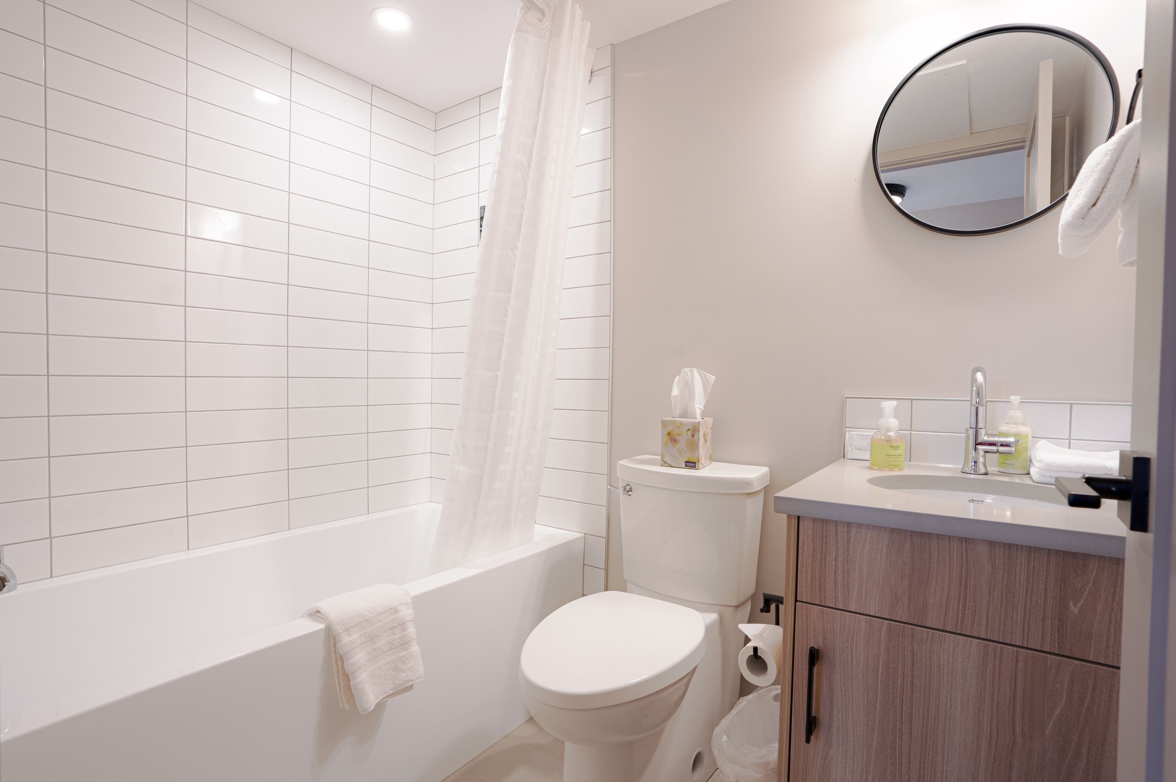 A modern bathroom with a bathtub, toilet, and sink.