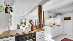 A modern kitchen with white cabinetry, a wooden countertop, and a built-in oven. - Cozy home in Højby with kitchen (Højby)