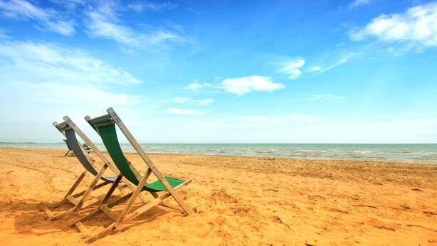 A beach with two wooden beach chairs and a clear blue sky. - Lovely apartment in Rimini with kitchen (Rimini)