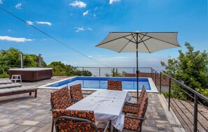Relax by the pool with a serene view of the surrounding landscape.