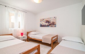 A bedroom with two single beds, a bedside table with a lamp, a window with sheer curtains, and a painting on the wall. - Awesome home in Zrnovnica (Zrnovnica)