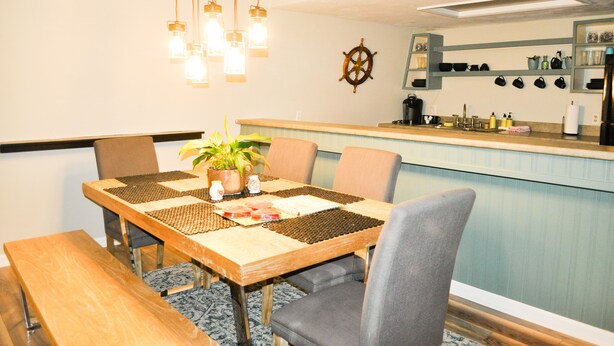 Un comedor con una mesa de madera, sillas y una planta en maceta.