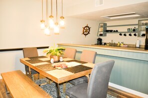 A dining area with a wooden table, chairs, and a potted plant.