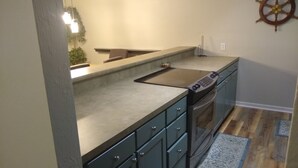 Una cocina con horno empotrado, microondas y estufa.