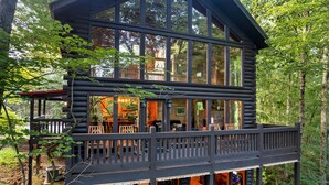 Eine Blockhütte mit einer Terrasse und einem überdachten Sitzbereich im Freien.