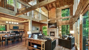Eine geräumige Holzhütte mit Essbereich, Küche und Wohnzimmer mit Kamin.