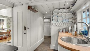 A kitchen with white cabinets, a sink, and a dish rack.