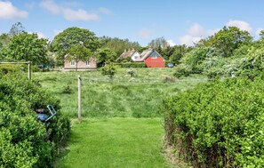 Escape to a serene rural haven surrounded by lush greenery and trees.