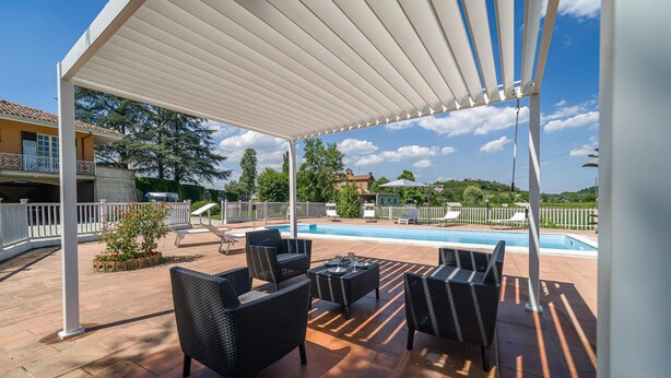 A covered outdoor area with a pool, lounge chairs, and a pergola. - Nice home in Asti with jacuzzi (Asti)