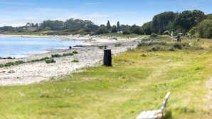 A beach with a grassy area, a few benches, and a path leading to the water. - Amazing home in Sydals with sauna (Sydals)
