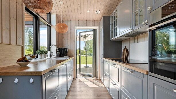 A modern kitchen with wooden ceiling, grey cabinets, and a wooden countertop. - Amazing home in Sydals with sauna (Sydals)