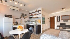 Ein kompakter Wohnbereich mit Küchenzeile, Essbereich und Schlafzimmer.