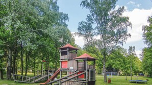 Ein Spielplatz mit Rutsche, Klettergerüsten und einem Netzbereich.