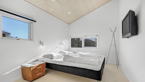 A bedroom with a bed, a bedside table, a TV, and a window. - Nice home in Skælskør with sauna (Skælskør)