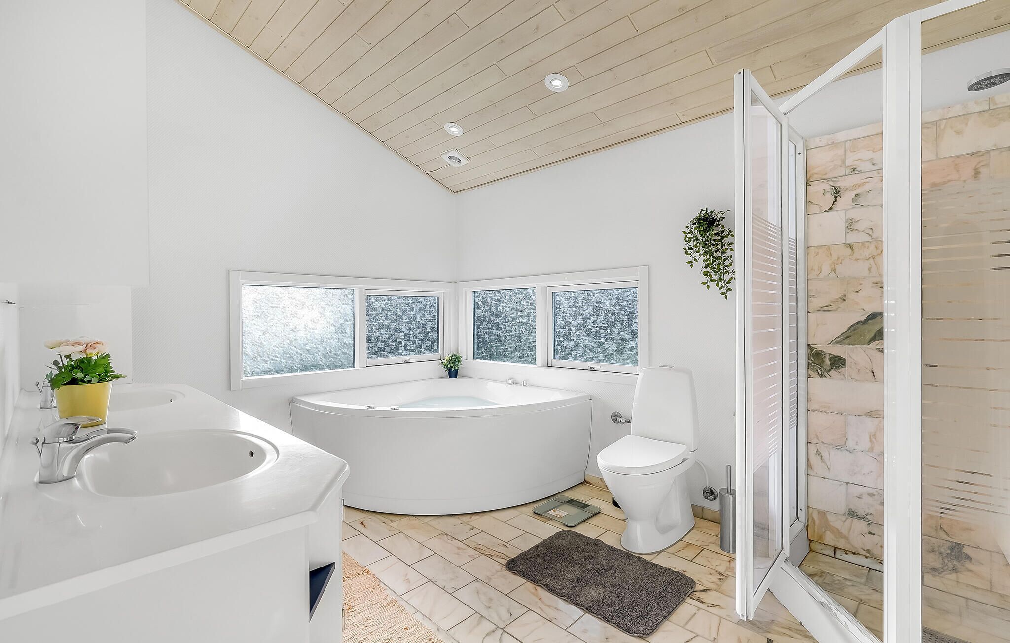 Ein modernes Badezimmer mit freistehender Badewanne, Toilette und Duschbereich.