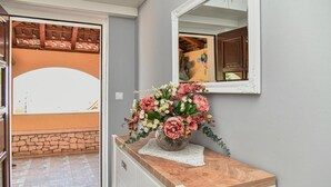 A bathroom with a wooden vanity, a mirror, and a floral arrangement on the vanity. - Amazing home in Postira (Postira)