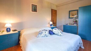 A bedroom with a bed, two nightstands with lamps, a dresser, and a door. - Nice apartment in Lido di Camaiore (Lido di Camaiore)