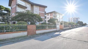 A residential street with modern apartment buildings, a gated entrance, and a clear sky. - Nice apartment in Lido di Camaiore (Lido di Camaiore)