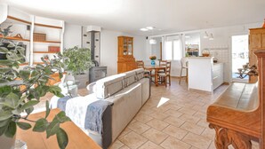 A spacious living area with a sofa, dining table, and kitchen island. - Amazing home in Salernes (Salernes)