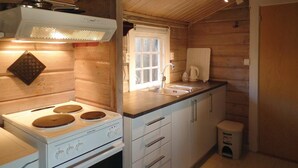 A compact kitchen with a white stove, a sink, and wooden cabinets. - Awesome home in Farsund with house sea view (Farsund)