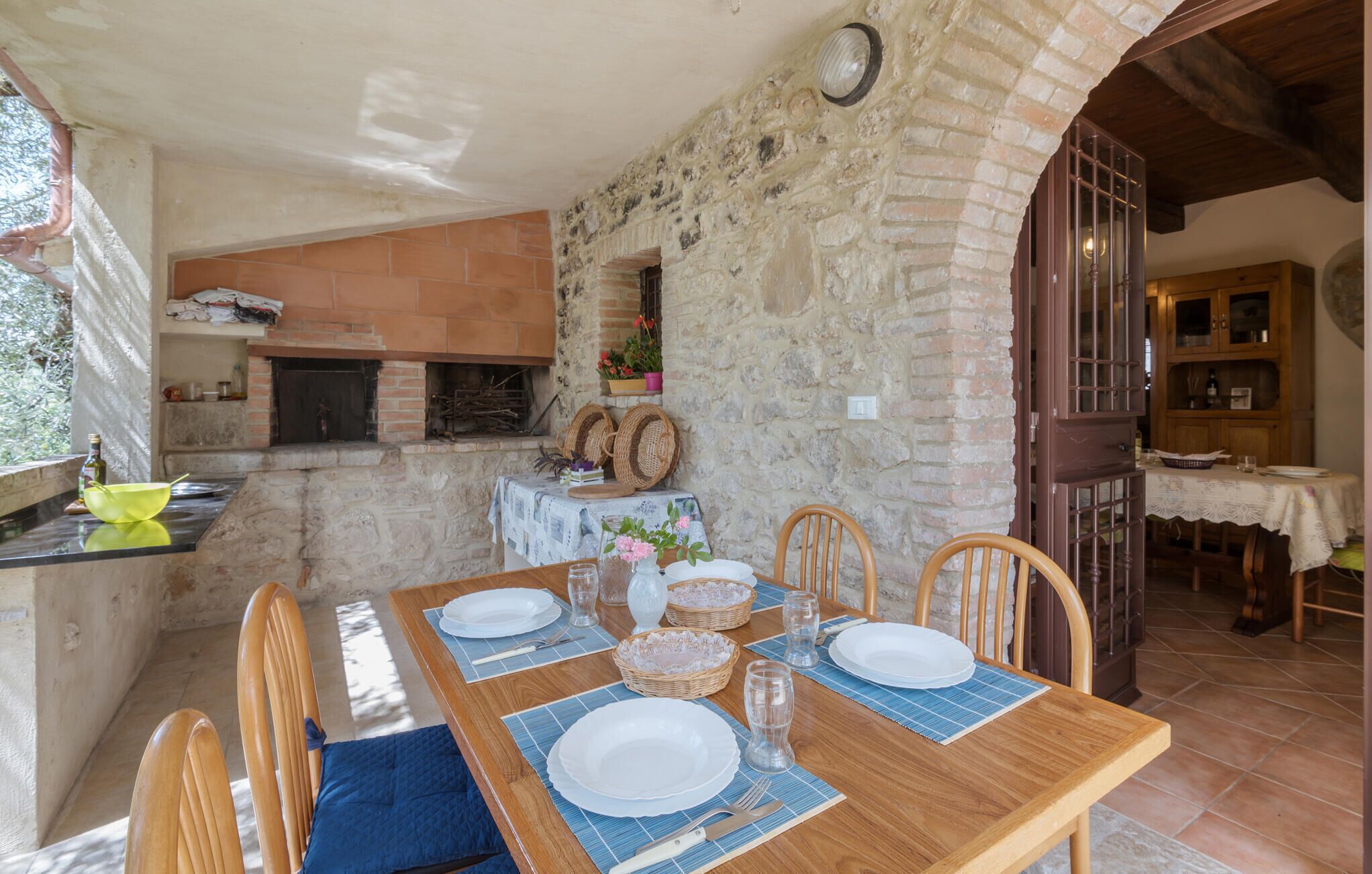 Un coin repas rustique avec un mur en pierre, une table en bois et des chaises.