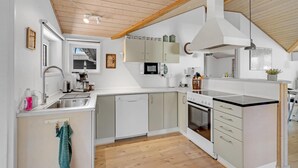 A modern kitchen with white cabinets, a built-in oven, a microwave, and a sink.