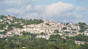 A densely packed hillside town with historic buildings and a prominent church tower. - "Tilleul" Room – Indulge in understated B&B luxury (Fayence)