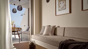 Ein modernes Wohnzimmer mit Sofa, Couchtisch und Blick ins Freie.