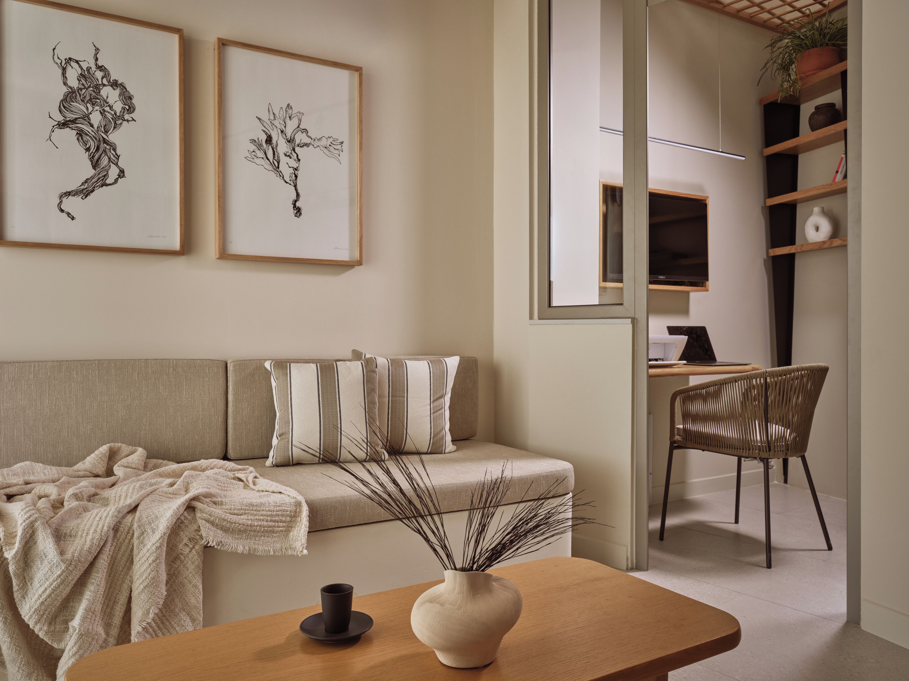 A modern living room with a sofa, a coffee table, and a desk area.